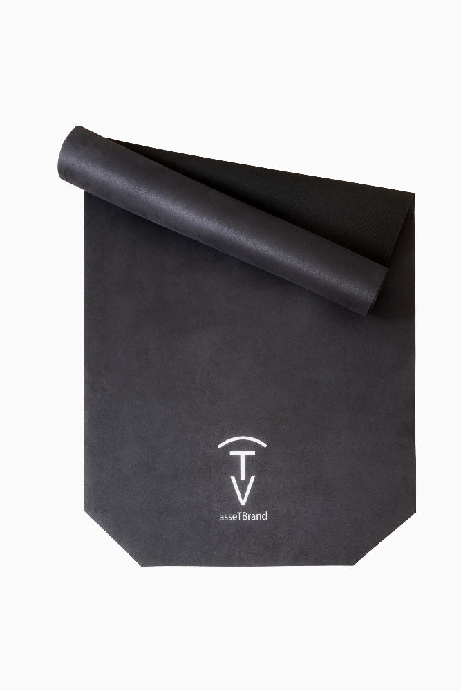 Rolled black non-slip yoga mat with soft suede-style microfiber top and natural rubber base