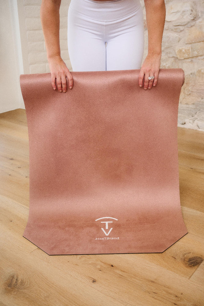 Woman unrolling a camel machine-washable yoga mat with non-slip microfiber surface indoors