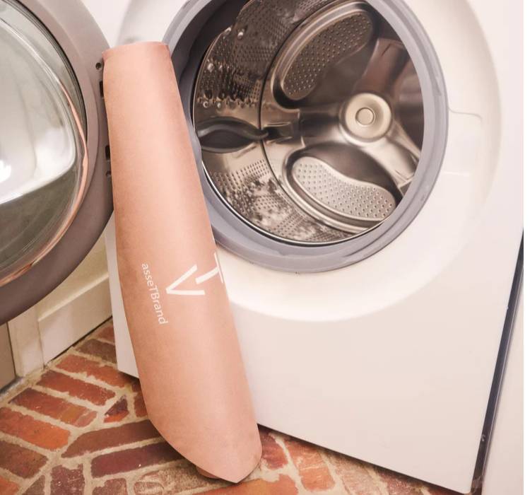 The machine-washable Asset Mat leaned against a washing machine